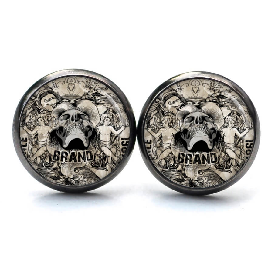Ohrstecker, Ohrhänger, Clipse & Druckknopf – Motiv Totenkopf mit 2 Jungen – Schmuck aus Edelstahl Ohrstecker, Ohrhänger, Clipse & Druckknopf – Motiv Totenkopf mit 2 Jungen – Schmuck aus Edelstahl